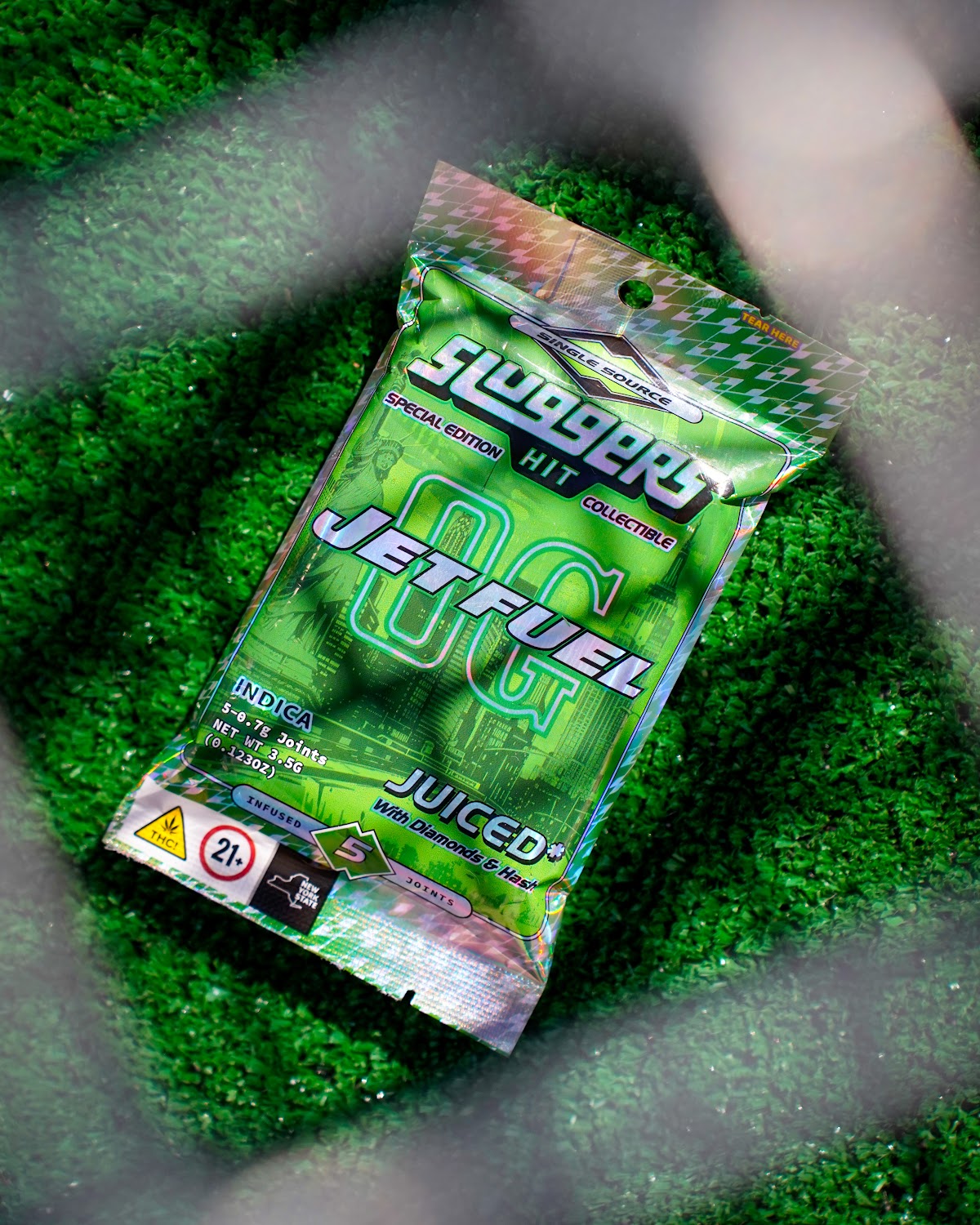 Cannabis pre-roll pack on green turf — cannabis product photography