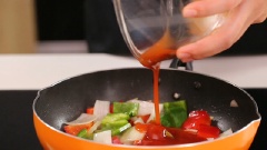 Làm nóng một chảo khác với 1 muỗng canh dầu. Nếu tận dụng chảo dầu cũ thì bạn chắt bớt phần dầu thừa, làm nóng chảo trở lại. Cho hành tây và ớt chuông, thơm vào xào thơm. Kế đó mới thêm nước sốt, đảo đều và đun cho đến khi nước sốt đặc lại.