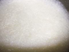 Cho gạo vào cối dùng để xay tiêu, xay nát 1/2 hạt gạo rồi cho vào nồi cơm điện vo nấu cơm như bình thường (cho hơi nhiều nước). Rửa sạch sườn non với muối rồi chặt nhỏ. Nấu nước hầm xương (thường xuyên hớt bọt).