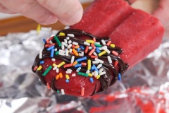 Khi kem gần đông cứng lại thì bạn tranh thủ làm chocolate với phương pháp đun cách thủy cho chocolate tan chảy hoàn toàn. Sau đó để chocolate nguội bớt ở nhiệt độ phòng. Kem vị củ cải đường đã đông cứng hoàn toàn thì lấy ra khỏi khuôn kem, nhúng đầu que kem với chocolate đã đun chảy, sau đó rắc thêm các hạt cốm nhiều màu lên trên phần chocolate đó và đợi chocolate đông lại là có thể thưởng thức!