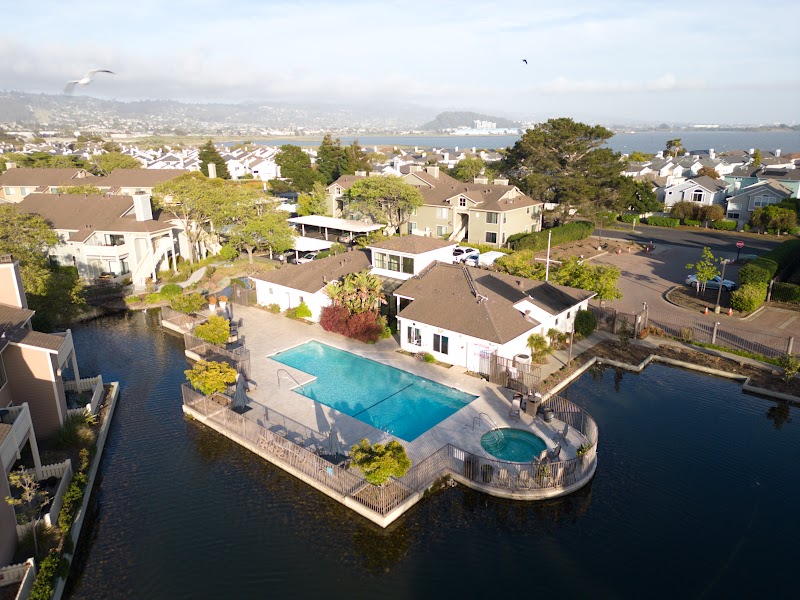 Aerial of waterfront homes with pools along the lagoon — shot by 3 Eye Media