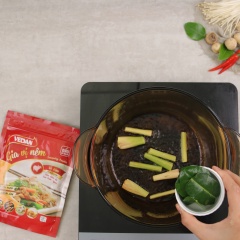 GTiếp tục, cho 1 muỗng canh dầu ăn vào nồi đun nóng, phi thơm 40gr sả khúc đập dập, 5gr lá chanh, 10gr hành tím lát cho dậy mùi, cho tiếp 100gr cà chua thái nhỏ vào xào mềm. Rồi đổ 1,8 lít nước luộc nghêu vào đun sôi, sau đó vớt bỏ sả khúc và lá chanh.
