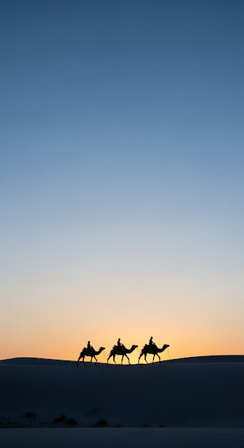 Silhouette of a Camel Caravan Crossing a Desert Dune at Twilight Against a Blue and Orange Sky