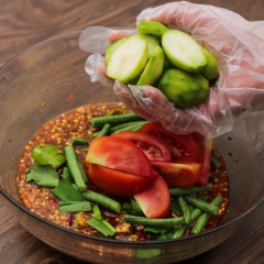 Đổ nước trộn gỏi vào tô lớn thêm 50gr đu đủ bào sợi, 50gr cà rốt bào sợi, 30gr rau ngò gai cắt nhỏ, 30gr đậu đũa cắt khúc, 2 trái cà chua bổ hình múi cau. Sau đó xếp chân gà và 50gr cóc rồi trộn đều.