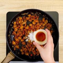 Bắc chảo khác lên bếp, cho khoảng 5 muỗng canh mỡ vào chảo, cho 100gr sả băm vào, đảo liên tục trên lửa vừa đến khi sả vàng đều thì cho tiếp 30gr ớt băm vào chảo, đảo đều. Tiếp đến cho thịt ba rọi, 1 muỗng cà phê muối vào chảo, đảo cho sả ớt thấm vào thịt thì nêm 1.5 muỗng canh nước mắm, 1 muỗng canh đường, đảo tất cả nguyên liệu trên lửa lớn.