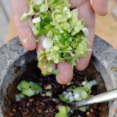 Hành lá rửa sạch, cắt nhỏ. Cho vào cối hỗn hợp tẩm gà. Trộn đều.