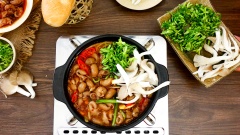 Tiếp theo cho thêm rau và nấm, rưới nước sốt sa tế ướp bao tử lên trên rau rồi xào cho tất cả chín đều rồi thưởng thức thôi.