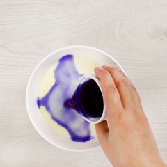 Sau đó, chia hỗn hợp sữa chua phô mai thành 4 tô bằng nhau. Tô thứ nhất cho 20ml nước cốt thanh long, trộn đều. Tô thứ hai cho 10ml Matcha đã pha loãng, trộn đều. Tô thứ ba cho 20ml nước cốt hoa đậu biếc. Sau đó, cho từng tô lên nồi nấu sốt cùng với 5gr bột bắp pha loãng, khuấy đều và nấu đến khi hỗn hợp đặc lại, tắt bếp, để nguội.