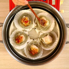 Cuộn khoanh miến lại cho gọn đặt vào trong vỏ sò, cho phần còi sò điệp lên trên. Rưới phần hỗn hợp dầu tỏi, ớt phi thơm phủ đều phần thịt sò. Đem hấp chín trong vòng 10 phút.
