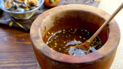 Làm nước mắm trộn sò huyết kiểu Thái: đầu tiên cho ớt xanh, ớt đỏ và tỏi vào cối giã cho nát. Sau đó thêm đường thốt nốt, dùng chày giã cho đường thốt nốt tan ra, thêm nước cốt me và nước mắm, khuấy đều cho tất cả hòa quyện.