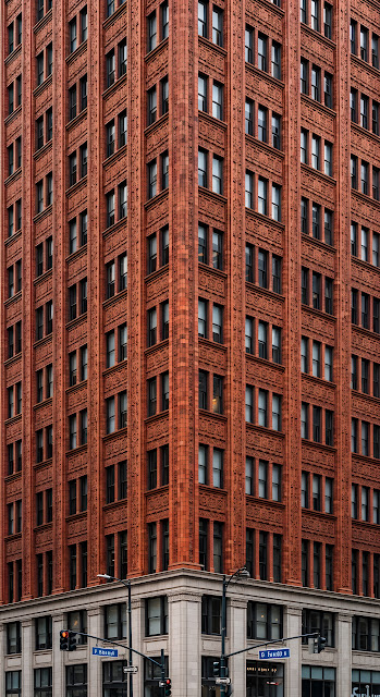 Close-Up of an Ornate Orange Terracotta Skyscraper Corner with Repeating Window Pattern - Free mobile Wallpaper