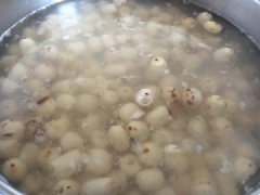 Xả nước cho sạch sen, sau đó thông tâm của những hạt sen còn sót và nhặt những hạt xấu ra. Trong lúc nhặt sen, bạn đặt 1 nồi nước lên bếp, đun sôi rồi thả hết sen vào luộc, thêm xíu muối tinh và muối nở vào (muối nở giúp mứt sen bở xốp, ngon hơn), nhớ đảo đều nhé!