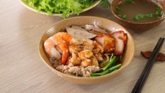 Chan phần nước sốt vào, cho thêm tiêu vào để tăng thêm hương vị. Trộn đều tất cả lên, có thể cho thêm hỗn hợp sốt cho vừa miệng. Dùng kèm với chén nước hầm xương, rắc ít hành lá và tiêu, thêm dĩa rau xà lách, giá, rau cần...
