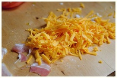 Thịt xông khói cắt nhỏ. Cho phô mai cheddar sợi ra đĩa cùng thịt xông khói.