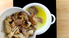 Cho vào nồi 1 muỗng canh dầu ăn, 1 muỗng canh dầu điều, đợi dầu nóng bạn cho gà đã ướp vào, xào cho gà săn lại.