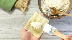 Chuẩn bị 1 chiếc tô sạch, cho lần lượt ức gà xé nhỏ, bắp nếp đã băm nhỏ, 5 miếng phô mai bò cười, 20gr đường, 2gr muối, 2gr tiêu xay vào tô, sau đó trộn đều cho phô mai và gia vị hòa quyện với các nguyên liệu khác. Chuẩn bị sẵn vỏ sủi cảo (hay gọi là vỏ hoành thánh), cho 1 số lượng nhân vừa đủ vào chính giữa, phết 1 ít nước xung quanh viền để kết dính sau đó gấp thành hình dáng mà bạn muốn.