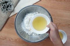 Làm bột nước cho bánh pía Sóc Trăng: Trộn đều 300gr bột mì và 2gr bột nở vào một chiếc thau nhỏ. Sau đó vun bột thành một cái núi nhỏ, khoét một lỗ ở giữa núi bột rồi cho 40gr đường, 80ml nước, 50gr dầu ăn, 50gr mỡ nước vào.