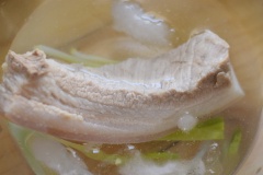 Đầu tiên bạn luộc thịt ba chỉ với đầu hành và hành tím rồi cho thêm một muỗng canh nước mắm để. Sau khi thịt đã chín, ngâm vào tô nước đá để thịt giòn và ngon hơn nhé.