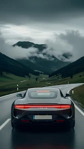 Dark Sports Car on Mountain Road Under Cloudy Sky