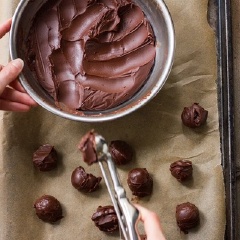 Lấy hỗn hợp chocolate đen ra, dùng dụng cụ, múc hỗn hợp thành từng viên tròn, nhỏ đặt trên khay nướng có lót sẵn một lớp giấy nến.