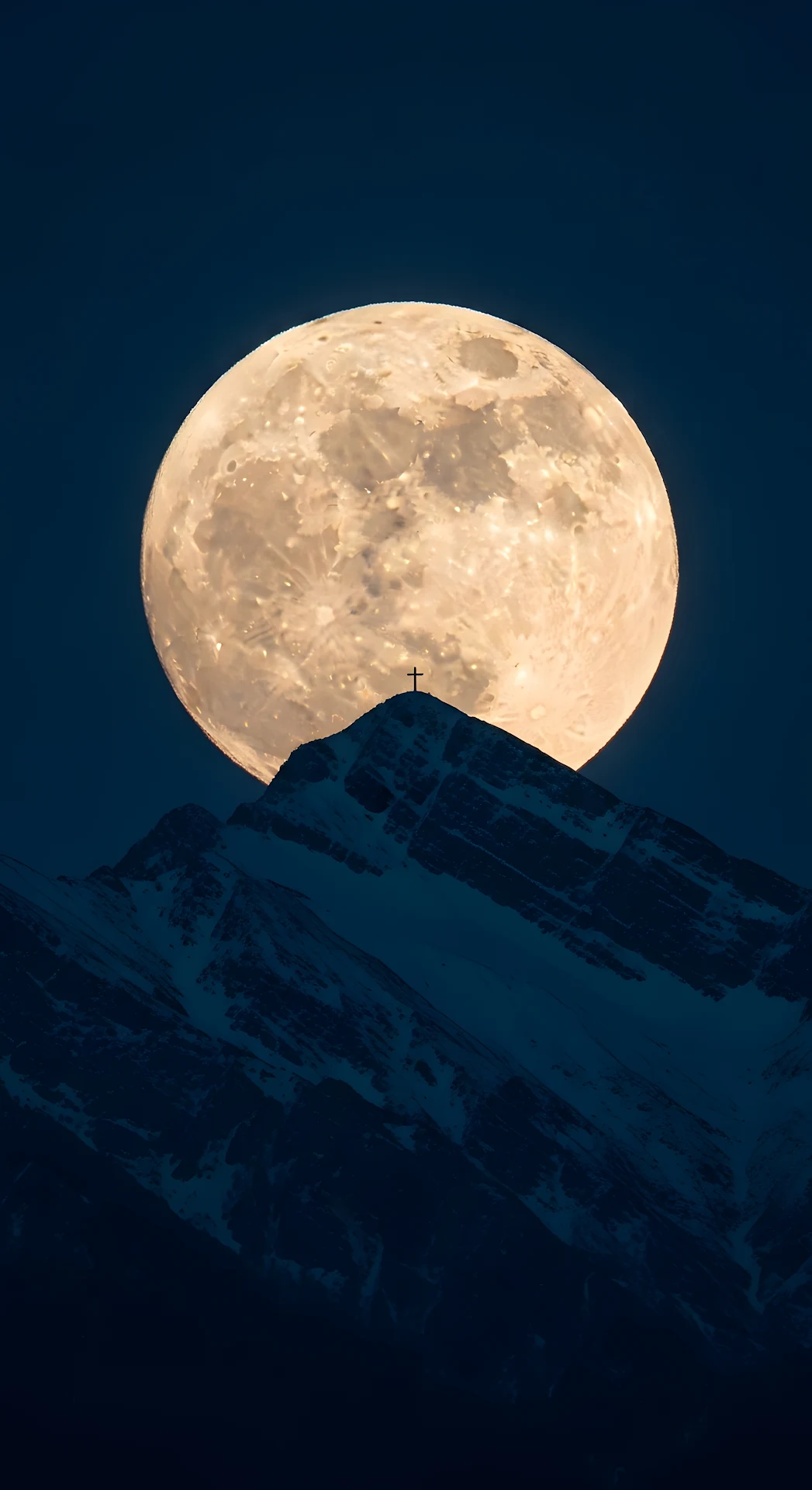 Giant Full Moon Setting Behind a Snowy Mountain Peak and Summit Cross Silhouette - Free 4K mobile Wallpaper