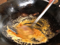 Đun chảy 1 muỗng canh bơ, cho lòng trứng trứng muối đã nghiền vào, thêm 1.5 muỗng canh nước dầu của sa tế tôm, đảo đều. Sau đó cho da cá hồi chiên giòn vào đảo cho da cá áo đều sốt trứng muối là được.