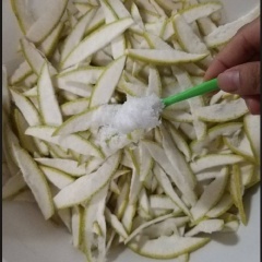 Cho 100g muối vào bỏ bưởi, xốc đều cho muối thấm vào vỏ bưởi. Để 15 phút cho muối tan lấy đi bớt bị đắng trong vỏ bưởi. Vắt và xả nước lại nhiều lần cho bớt vị đắng của vỏ bưởi. Nhai thử 1 miếng vỏ cảm thấy bớt vị đắng là vỏ đạt. Sau đó, vắt khô vỏ bưởi.