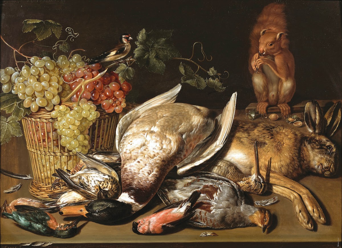A basket of red and green grapes a goldfinch game and a squirrel on a wooden tab
