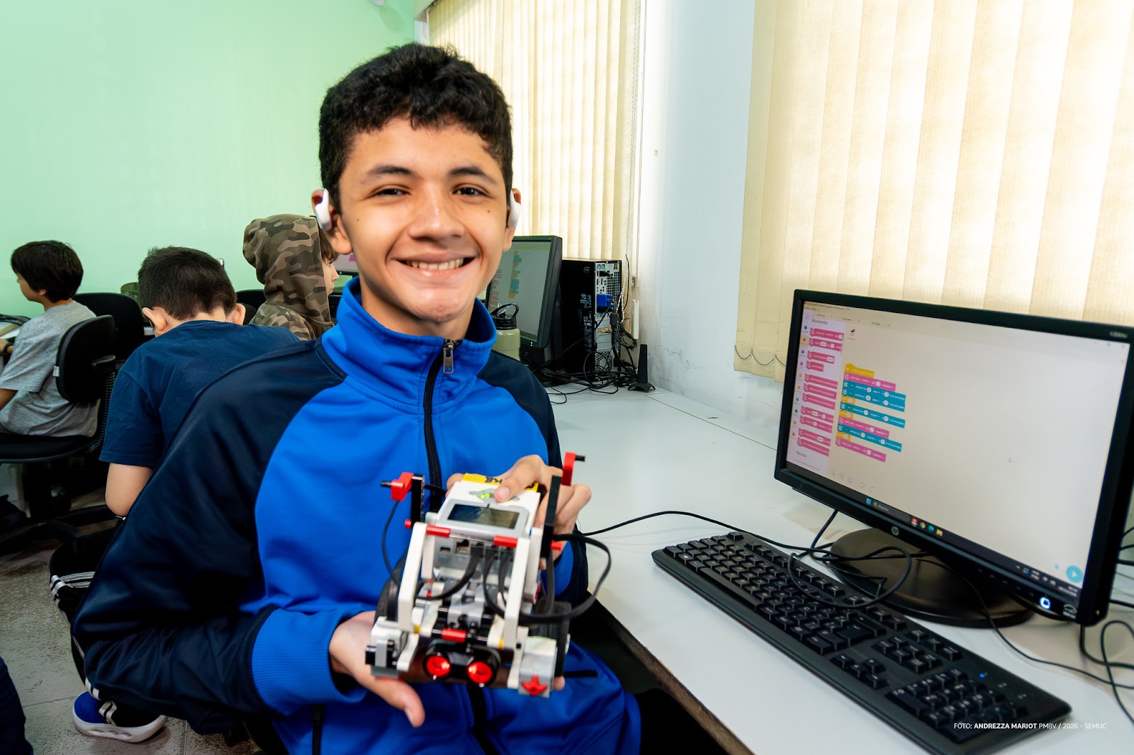 Professor orienta estudante durante teste de programação em protótipo de robótica educacional em Boa Vista