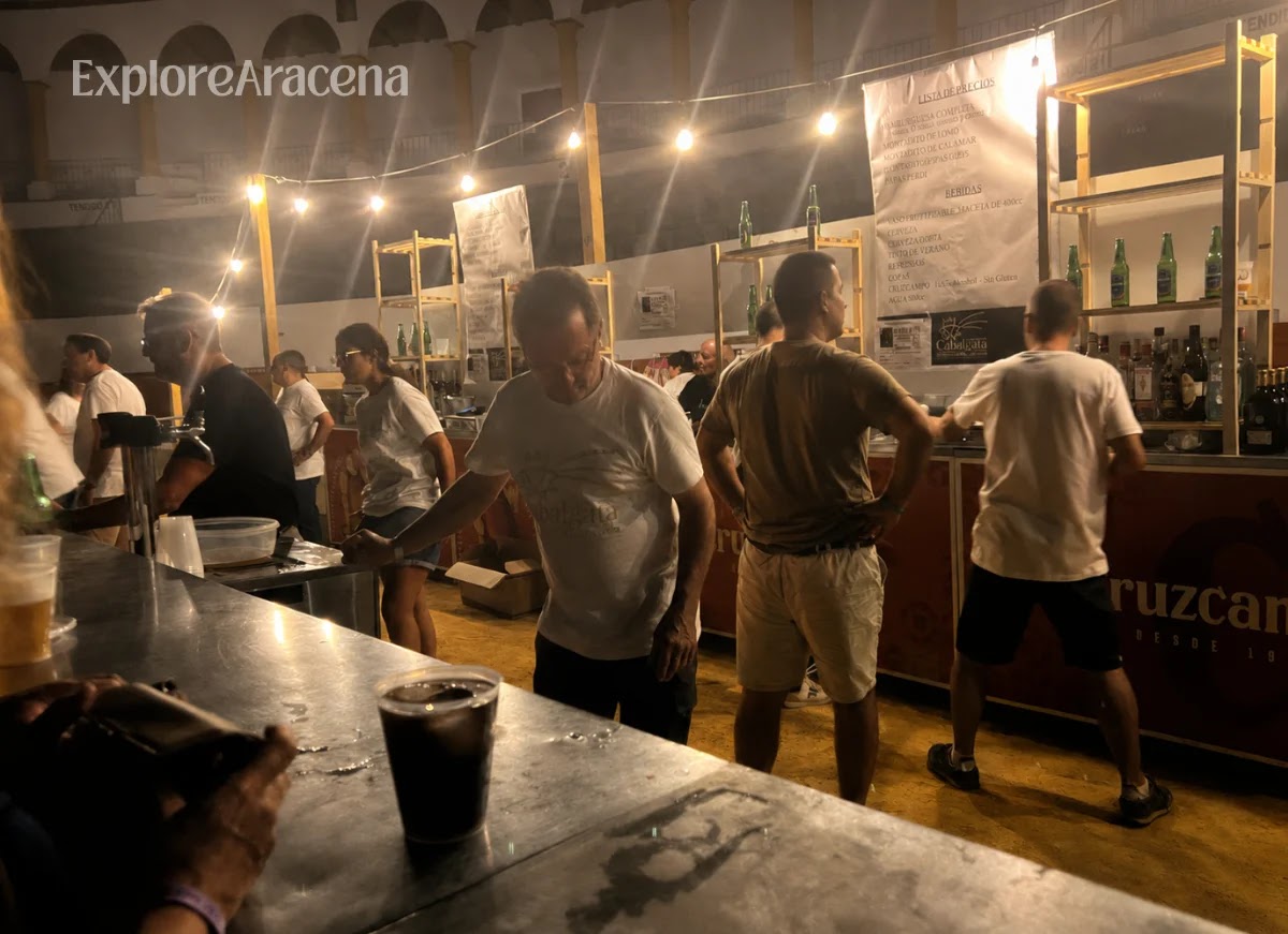 Festival-goers ordering drinks from the outdoor bar inside the Aracena Blues venue.