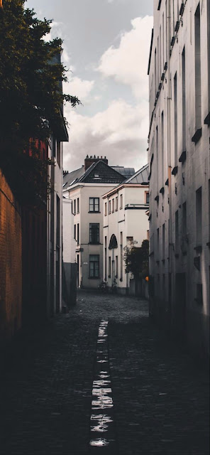 Moody Cobblestone Alleyway Between Tall European Buildings - Free mobile Wallpaper