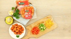 Để làm món salad xúc xích nhồi bơ này thì nguyên liệu chính bạn không thể thiếu đó là xúc xích. Sử dụng 100gr xúc xích cocktail Le Gourmet, đem xúc xích cắt thành những hạt lựu đều nhau. 2 trái bơ cắt làm đôi, bỏ hạt. 25gr cà chua, 25gr ớt chuông vàng, 25gr dưa leo, tất cả đem bỏ lạt rồi cắt thành hạt lựu cùng kích thước với xúc xích.