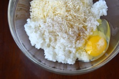 Cho cơm, phô mai parmesan và 1 quả trứng vào tô và dùng tay trộn đều hỗn hợp lên (đừng làm cho cơm nát quá nhé).