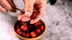 Đầu tiền dùng 1 chiếc đũa nhỏ đục 1 lỗ thủng xuyên ngay tâm trái táo gai để loại bỏ hạt và cuống táo. Tiếp đến xiên chúng vào những que như xâu kẹo hồ lô.