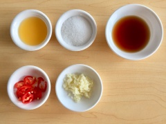Chuẩn bị nước mắm: Cho 2 muỗng canh đường, 2 muỗng canh nước mắm, 1 muỗng canh nước cốt chanh vào chén nhỏ, dùng muỗng khuấy tan đường, tiếp theo cho tỏi băm và ớt trái cắt lát vào trộn đều.
