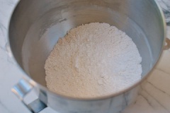 Đầu tiên cho 3g men nở, 12g đường, 177ml nước ấm vào âu lớn rồi dùng muỗng khuấy đều và để 15 phút cho men nở. Trong khi đó, cho 290g bột mì, 20g bột bắp, muối cùng baking soda vào âu khác trộn đều. Khi men đã ủ xong thì đồ bột vào, trộn thât đều. Lấy bột ra nhào thành khối bột dẻo mịn, mượt và không dính tay rồi đậy lại bằng khăn ẩm, ủ bột 1 tiếng cho bột nở gấp đôi là được.