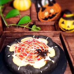Bánh pizza đen Halloween được tạo hình như một động nhện. Đây là món ăn mặn trông không kinh dị lắm nhưng cũng phủ hợp với không khí của ngày lễ hoa trang Halloween rồi nhé!
