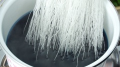 Đầu tiên bạn chuẩn bị một nồi có 1 lít nước lọc, bắc nồi lên bếp đun đến khi nước hơi nóng thì thả 30 hoa đậu biếc khô (khoảng 2gr) vào nồi rồi đun sôi. Chờ màu hoa đậu biếc hòa tan vào nước thành màu xanh đậm thì vớt xác hoa ra ngoài. Cho 100gr miến khô vào nồi nước, luộc miến 3 phút rồi tắt bếp, ngâm thêm 2 phút nữa đến khi sợi miến ngấm màu xanh đẹp của hoa đậu biếc.