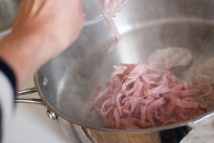 Đun nóng 1 muỗng canh dầu ăn, cho tôm vào xào sơ rồi cho thịt xông khói vào, đảo đều tay.