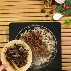 Phi thơm 1 muỗng canh hành tím băm, cho thịt ba chỉ ướp sẵn và xào săn, cho tiếp 50gr mọc nhĩ ngâm nở thái nhỏ, 50gr nấm hương thái nhỏ xào chín, cho thêm 1 muỗng cà phê tiêu xay rồi đảo đều.