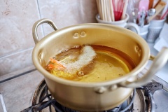 Đun nóng nhiều dầu ăn trong một nồi nhỏ, lăn tôm và một lớp bột chiên giòn khô cho áo đều rồi nhúng vào hỗn hợp bột ướt, thả vào chảo chiên ngập dầu cho vàng giòn, vớt tôm chiên giòn ra để ráo dầu.