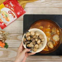 Cho tiếp 50gr củ cải, 50gr cà rốt tỉa hoa vào, nêm thêm 1 muỗng canh gia vị nêm VEDAN gà và trút phần nấm rơm xào vào và đun sôi lại một lần nữa.