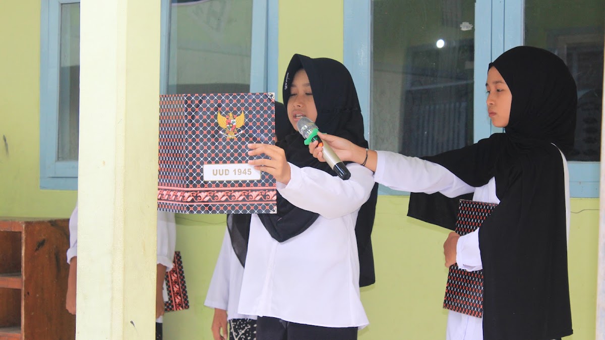 Petugas membaca teks Undang-Undang Dasar 1945 dari map di depan mikrofon