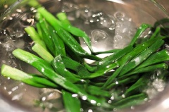 Rửa sạch hành lá, chần qua nước sôi cho mềm. Dùng lươn đã cắt khúc để cuộn một chút thịt băm, ngoài cùng gói bằng lá lốt và cột lại bằng lá hành cho chặt.