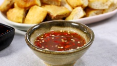Làm nước chấm bánh sữa chiên: ngâm 50gr me vào 100ml nước ấm trong 10 phút. Lọc bỏ xác me, giữ lại nước cốt cho vào nồi nhỏ. Đổ thêm 50ml nước, 100gr đường và 30ml nước mắm. Nấu sôi 10 phút và tắt bếp để nguội, thêm ớt băm nhỏ vào chén nước chấm me và khuấy đều.