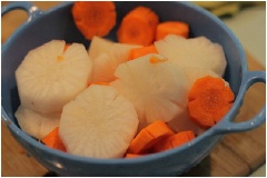 Củ cải trắng, cà rốt rửa sạch, gọt vỏ, cắt khoanh tròn. Bò viên rửa sạch, cắt làm đôi.