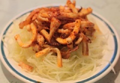 Trước khi ăn vắt đu đủ cho ráo nước, cho đu đủ ra đĩa, bên trên thêm mực, đậu phộng rang và rau húng quế, trộn đều lên.
