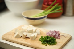Đầu tiên là sơ chế các nguyên liệu. Trứng cút luộc chín sau đó bóc vỏ. Cắt hạt lựu lần lượt đậu hũ non, cà chua; băm nhỏ hành tím và cuối cùng là cắt nhỏ hành lá.