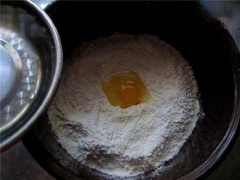 Rây 250g bột mì vào thố lớn, thêm vào 3g muối, 1 quả trứng. Rưới từ từ nước lọc vào thố bột, trộn đều lên. Sau đó dùng tay nhồi sơ cho bột thành khối, để yên 20 phút cho bột ngấm nước.