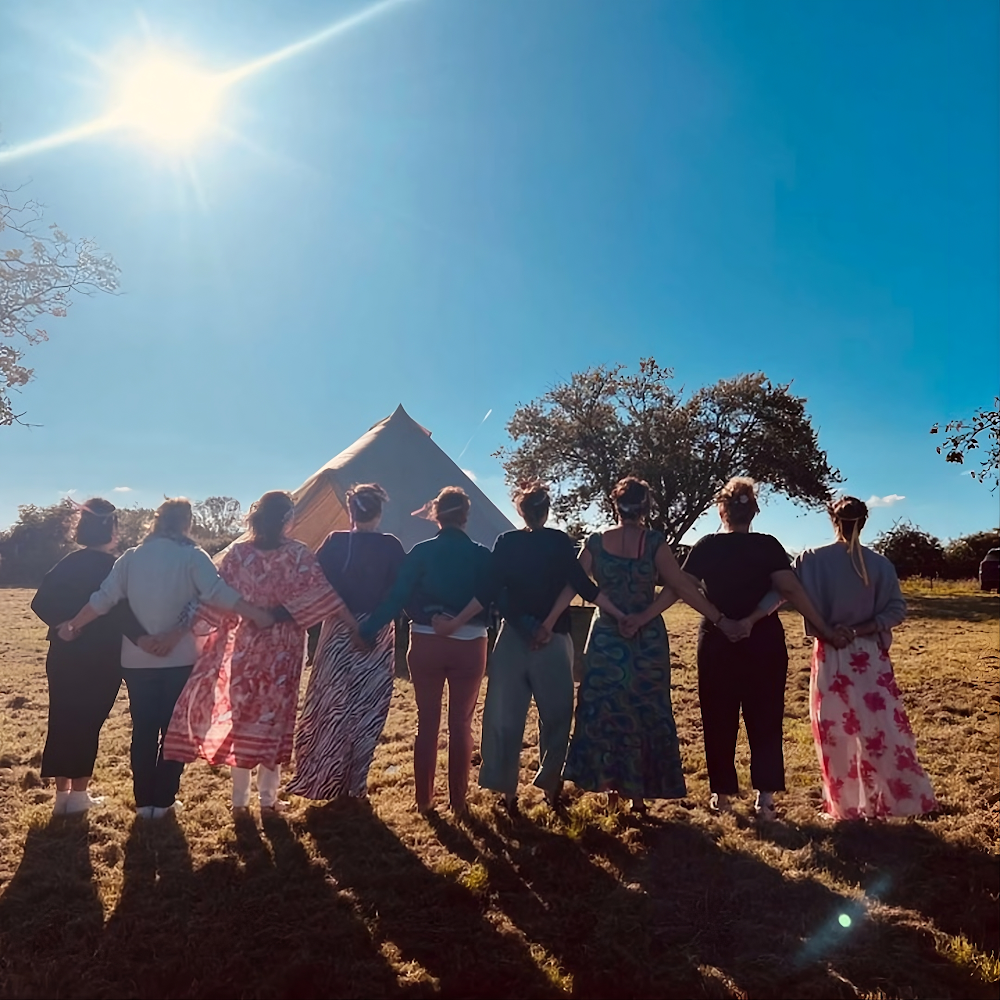 Groupe de femmes de dos, main dans la main face au ciel, rythme du parcours